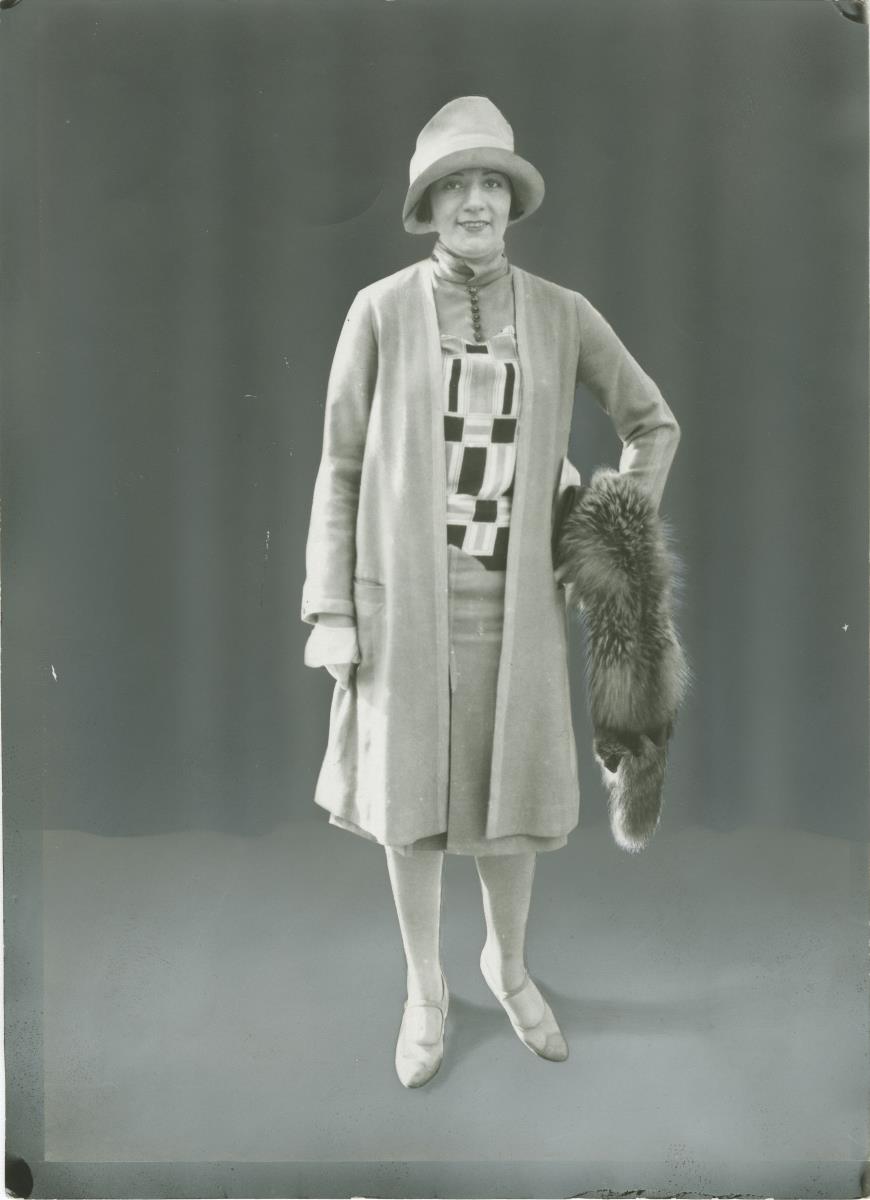 Frau in Kleid und Mantel auf dem Rennplatz in Auteuil