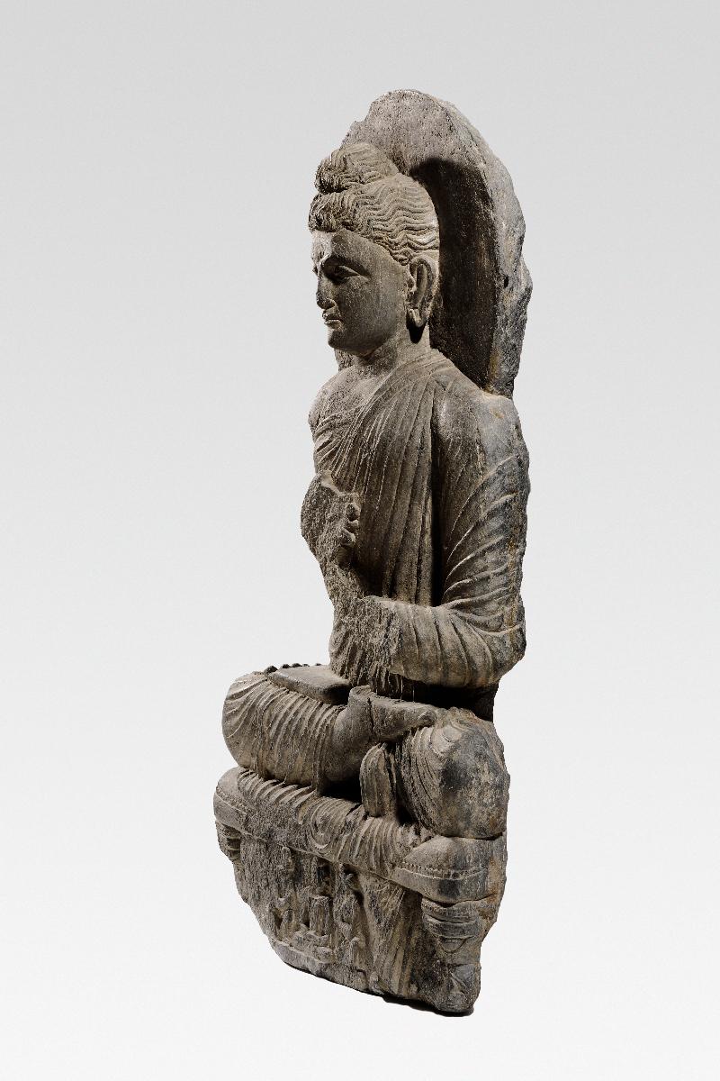 Sitzender Buddha in Lehrgeste (dharmachakra-mudra) auf Löwenthron mit Vorhangmotiv (Fragment). Sockelrelief: Verehrungsszene mit meditierendem Buddha und zwei Adoranten (Fragment).