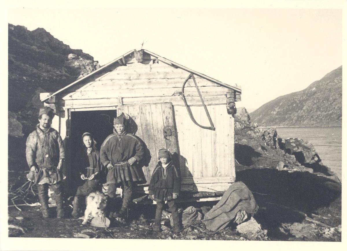 Samenfamilie vor einem Holzhaus
