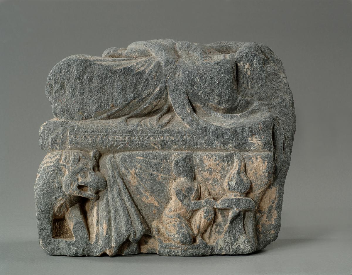 Unterkörper eines meditierenden Buddha auf Löwenthron mit Vorhangmotiv (Fragment). Sockelrelief: Knieender Adorant vor Feuerständer (Fragment)