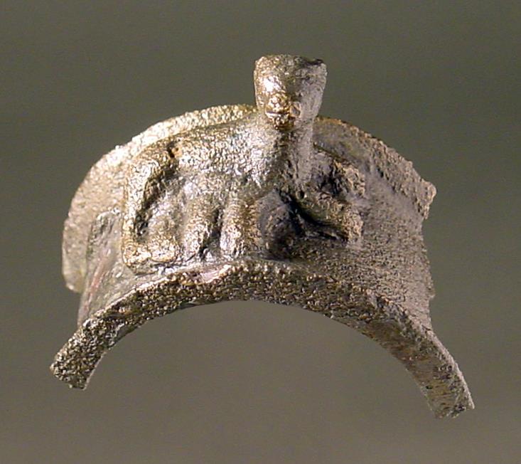 "Hälfte eines breiten Rings, darauf eine gelagerte säugende Hündin" (tatsächlich Teil eines ägyptischen Sistrums mit säugender Katze)