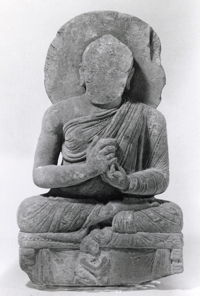 Sitzender Buddha in Lehrgeste (dharmachakra-mudra) auf Thron mit Vorhangmotiv (Fragment). Sockelrelief: Knieender Adorant