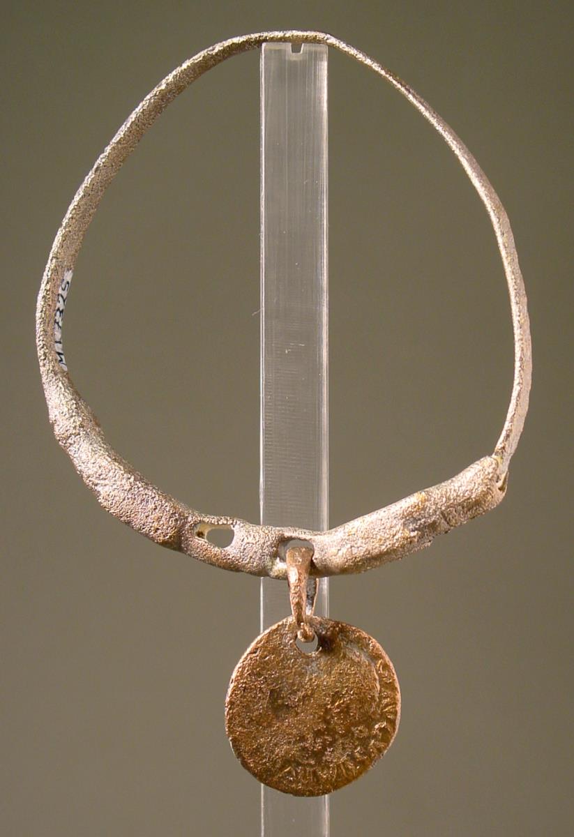 Armring, in zwei Hundeköpfe ausgehend, in deren Maul zwei Münzen hingen (eine ist erhalten: Tiberius 34 n. Chr.)