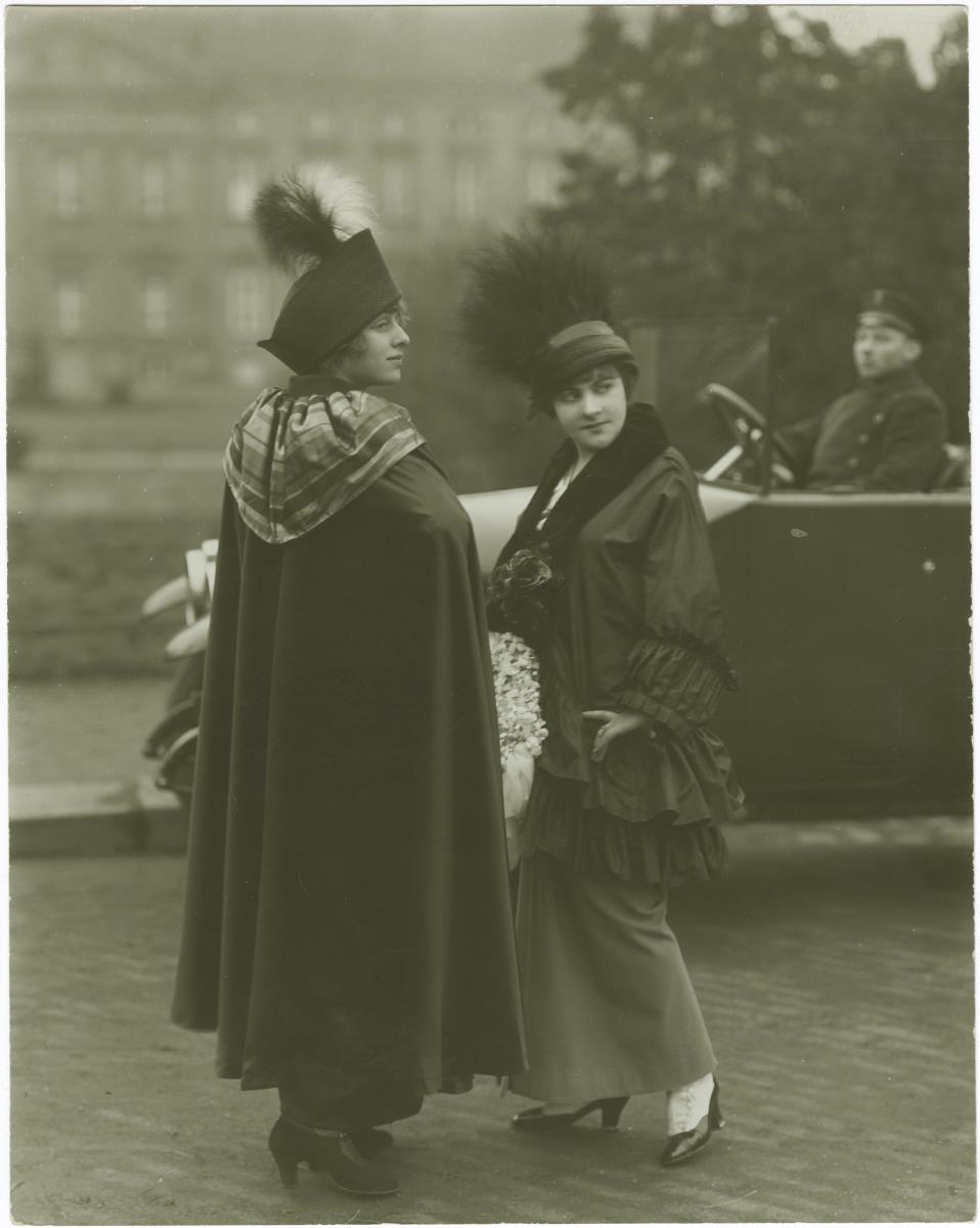 Frauen in Cape und Jacke und Rock