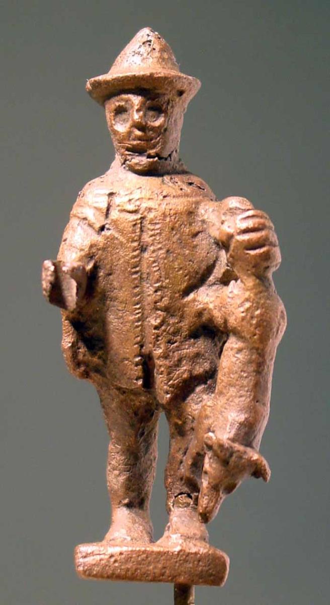 Archaische Statuette eines Jägers mit Chlamys und Hut, in der Linken einen Fuchs am Schwanz tragend
