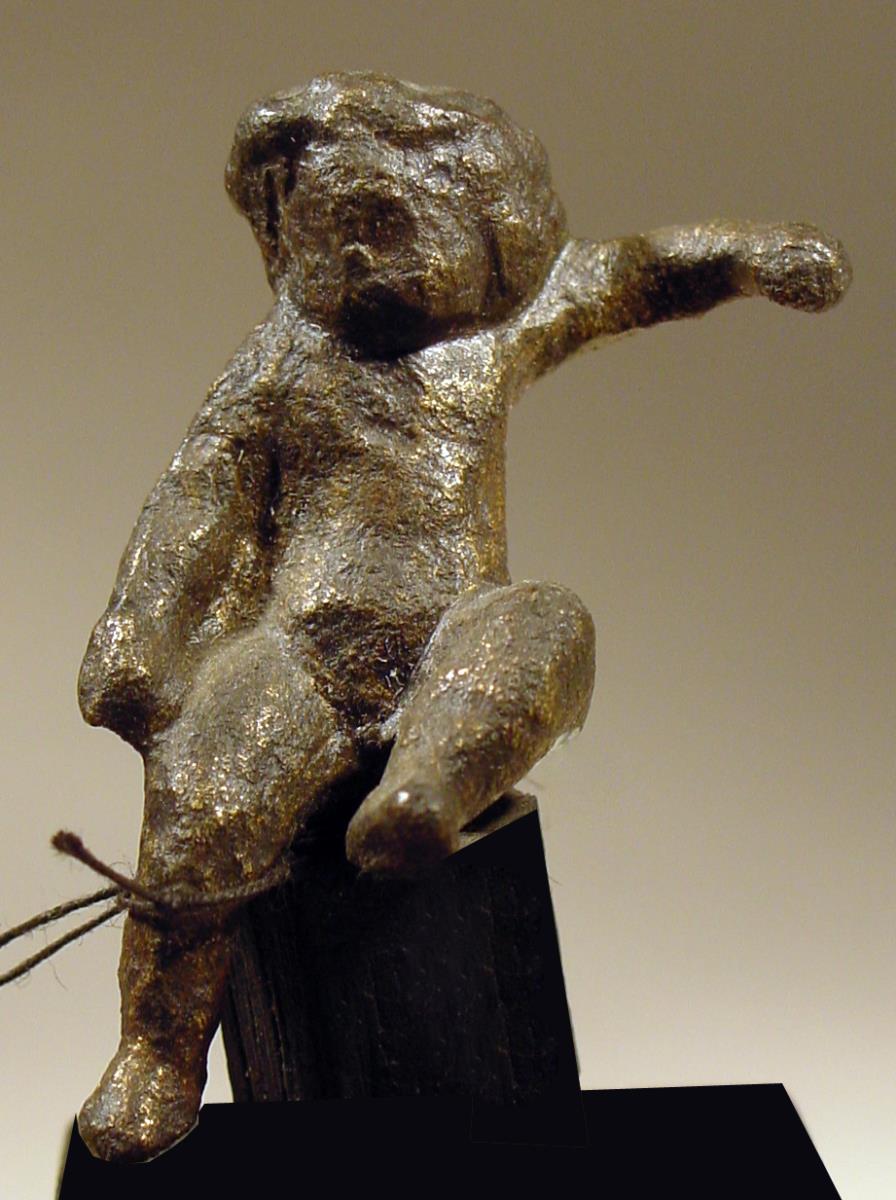 Statuette eines sitzenden nackten Knaben