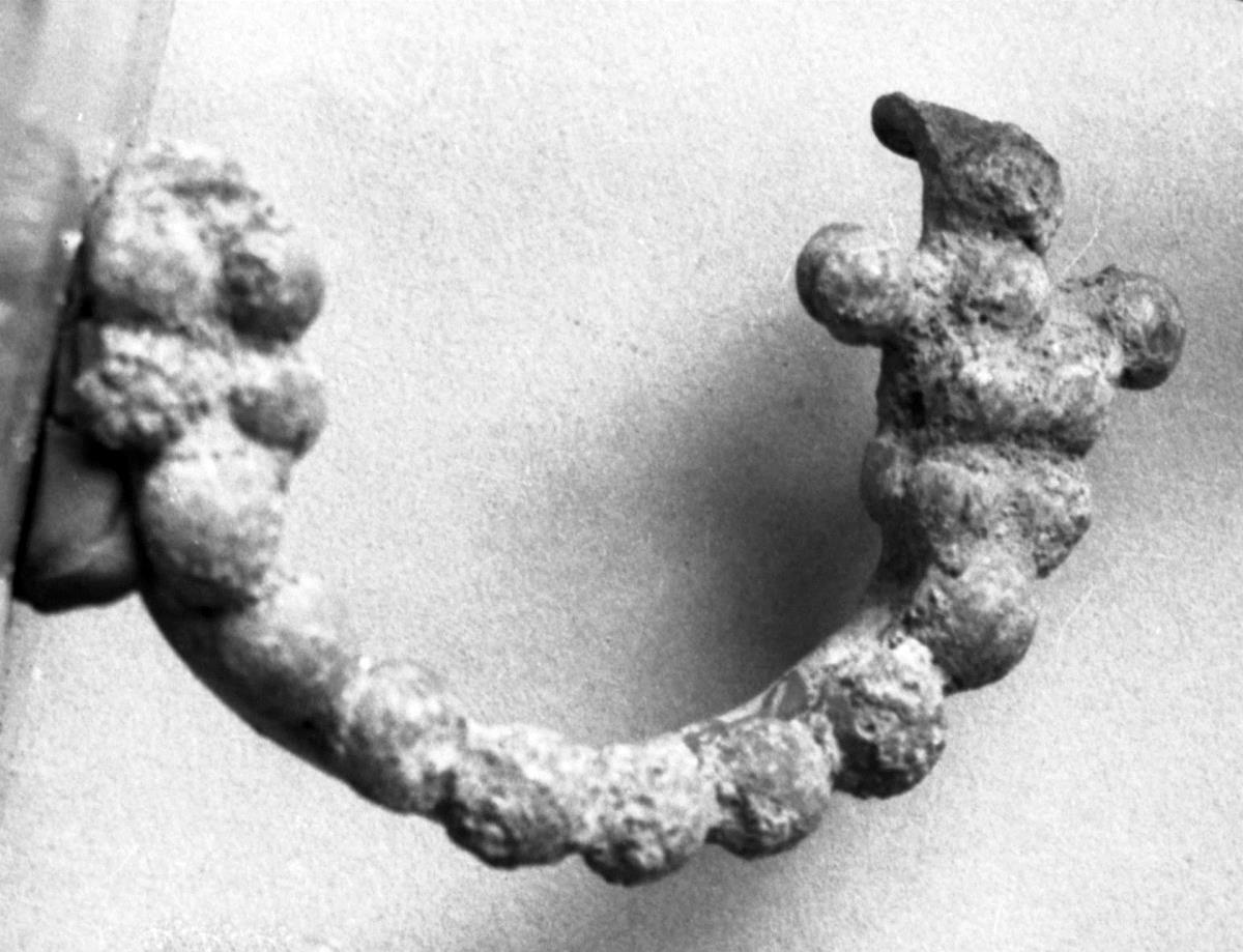Gegossene, halbrunde Fibel mit Perlenknöpfen