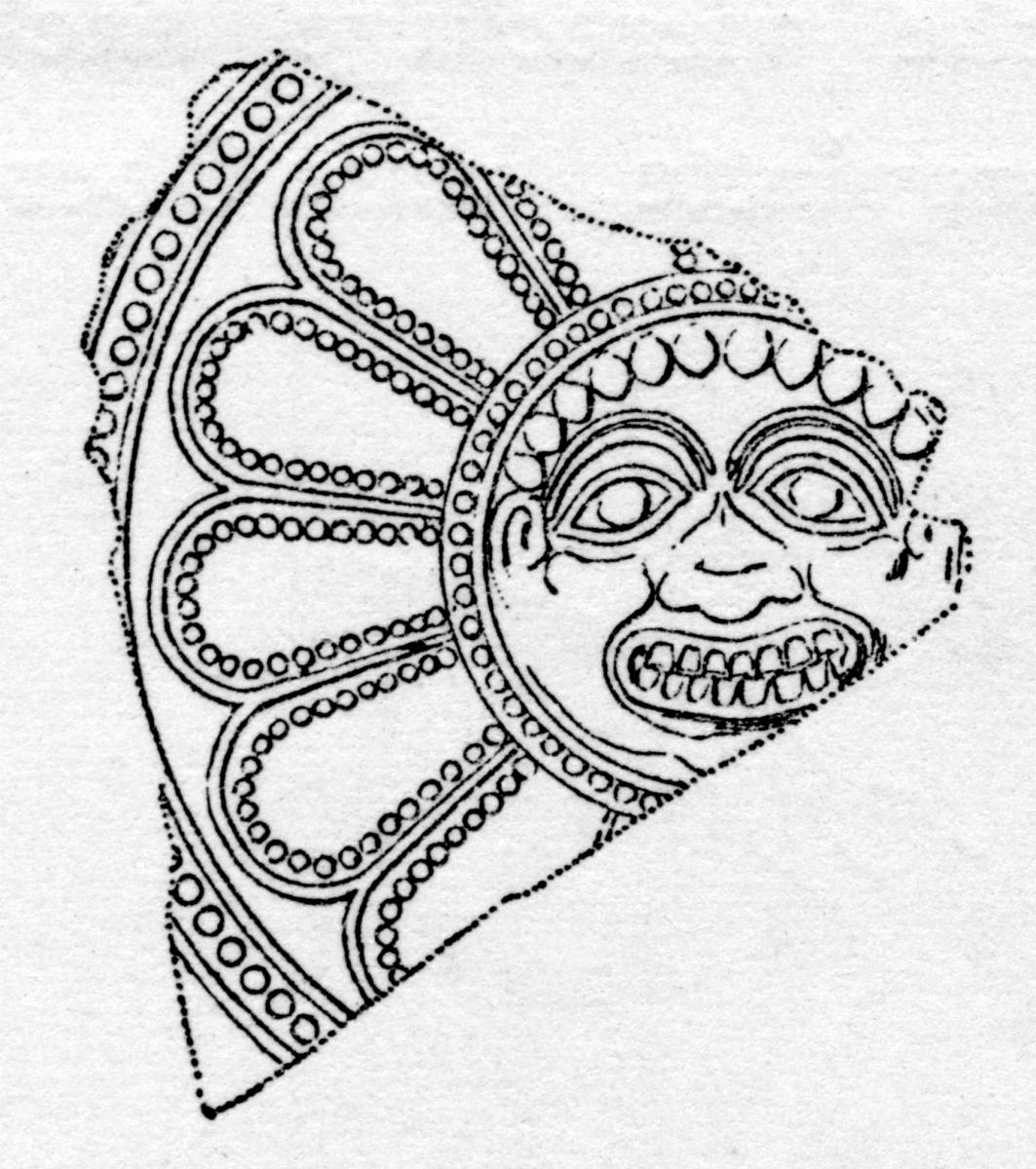 Fragment einer großen Rosette aus dünnem Blech, die einzelnen Blätter sind durch Punkte eingefasst, das Ganze von einem Punktkreis umgeben. Der Kern wird durch ein Gorgoneion ausgefüllt.