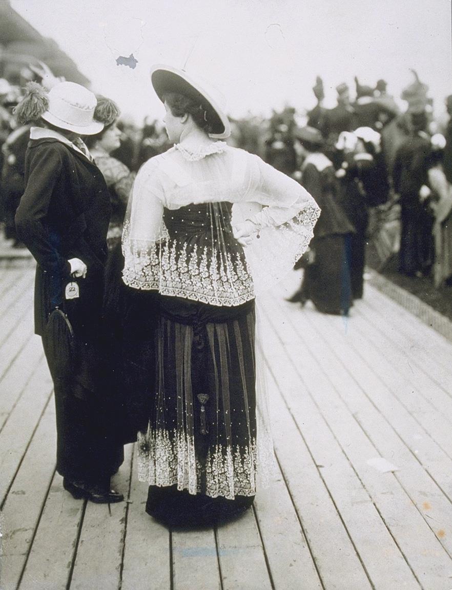Frauen in Kleid und Jacke und Rock auf dem Rennplatz
