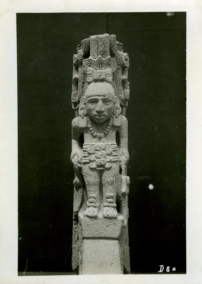 Vorderansicht einer Steinfigur, oberer Teil abgebrochen, Seitenteile mit reicher stilisierter Ornamentik. Sammlung Guillermo de Heredia.