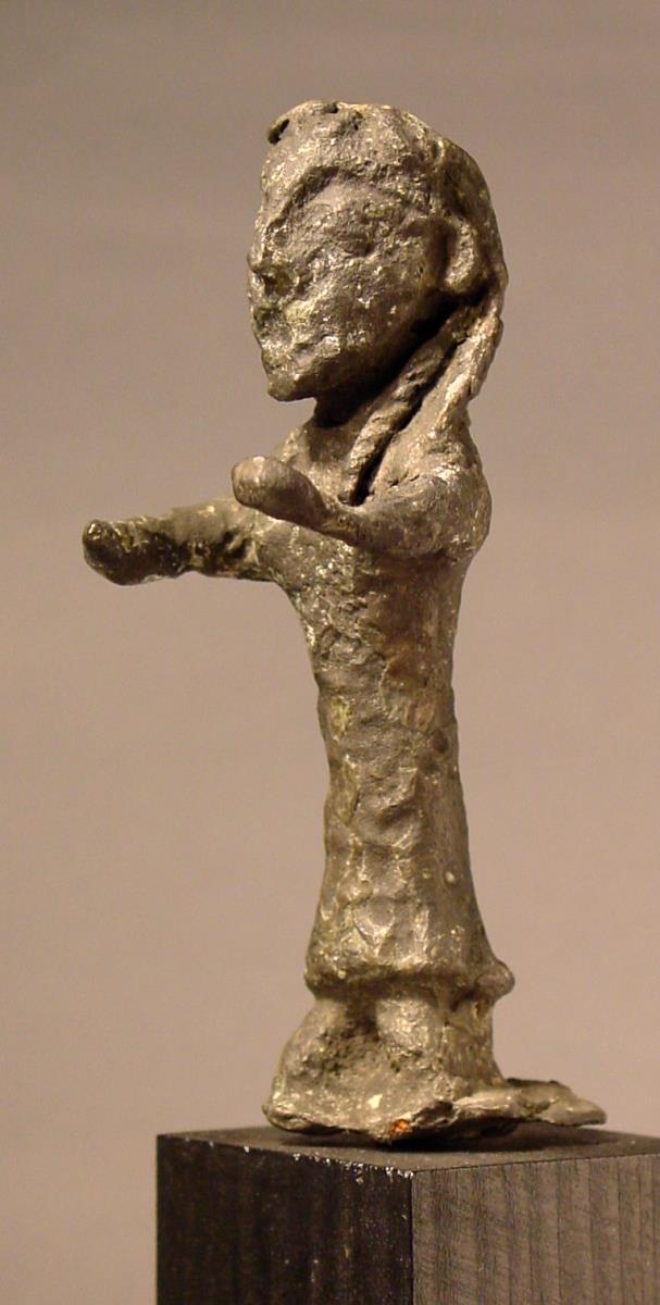 Primitive Statuette einer Frau. "Rohes, sehr stark oxydiertes Figürchen mit großem, plumpen Kopf und vorgestreckten Armen"