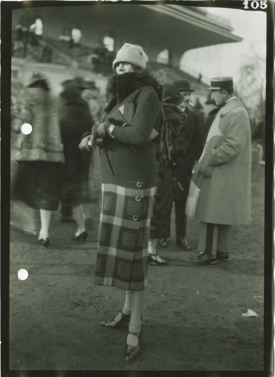 Frau in Mantel auf dem Rennplatz