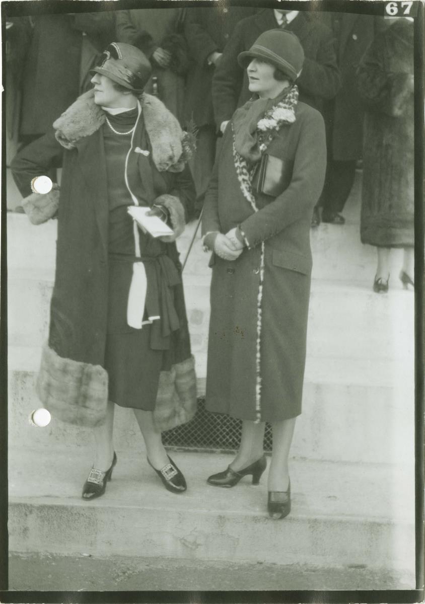 Frauen in Mänteln auf dem Rennplatz