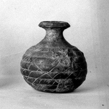 Miniaturgefäß in Form einer bauchigen Amphora (Henkel fehlen) mit Imitation von Korbgeflecht; oben ein kleines rundes und daneben ein größeres bohnenförmiges Loch