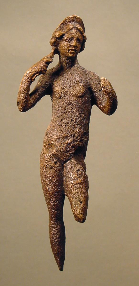 Römische Statuette einer nackten stehenden Aphrodite-Venus mit Diadem, die sich mit der Rechten das Haar ordnet, während die durchbohrte Linke ursprünglich wohl einen Spiegelgriff hielt, r. Fuß und l. Unterbein ab, letzteres vorhanden