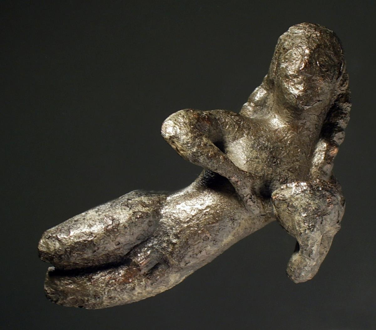 Statuette eines nackten Gelagerten, vom Rand eines Kessels, Beine unterhalb der Knie fehlen, Trinkschale in der aufgestützten Linken