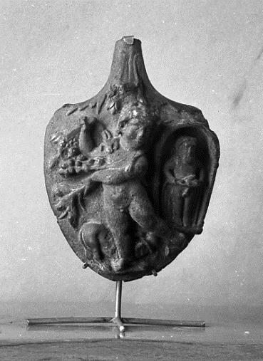 Fragment eines Henkels mit ungewöhnlich reich reliefierter Attasche: Bacchusknabe mit Früchten und Zweigen, rechts Priap in einer Grotte
