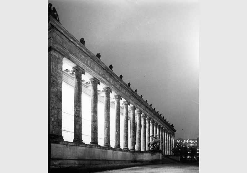 Blick auf die Löwenkämpfergruppe von Albert Wolff vor dem beleuchteten Eingangsbereich des Alten Museums