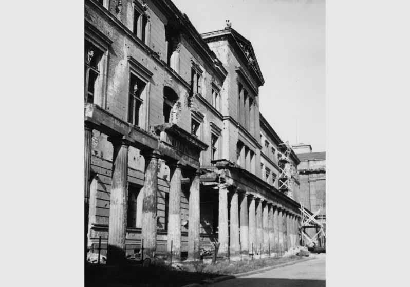 Blick auf die zum Teil zerstörte Fassade des Neuen Museums und die Kolonnaden