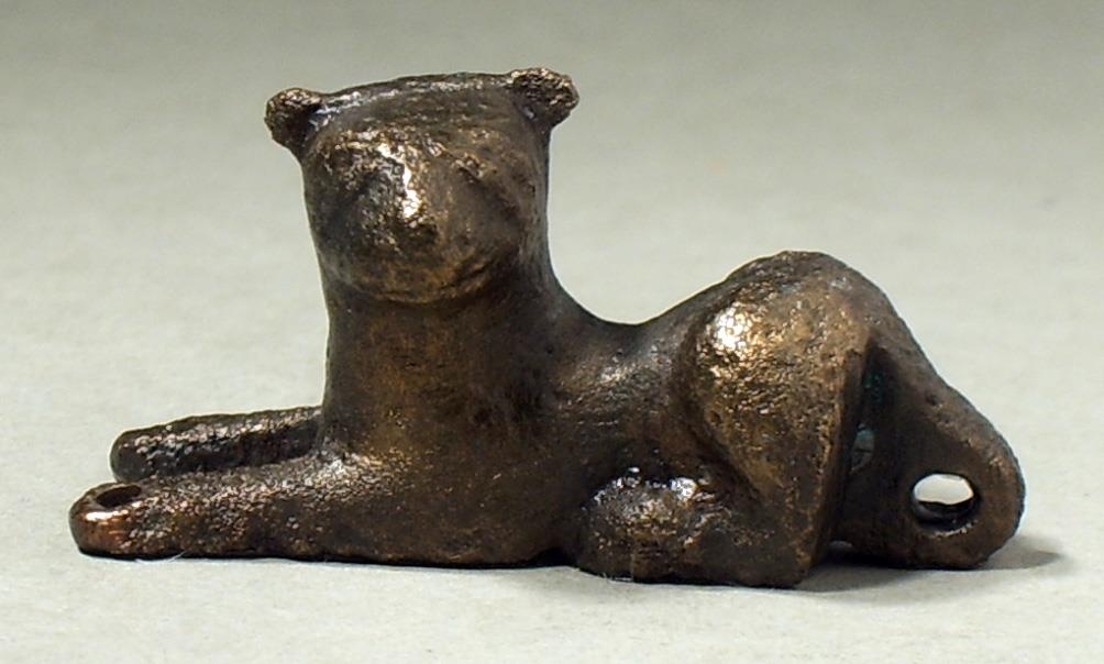 Liegender Löwe, von einem Gerät (Deckel?); Öse am Schwanz, Vorderbeine durchbohrt, Unterteil hohl, mit Blei gefüllt, reduziert