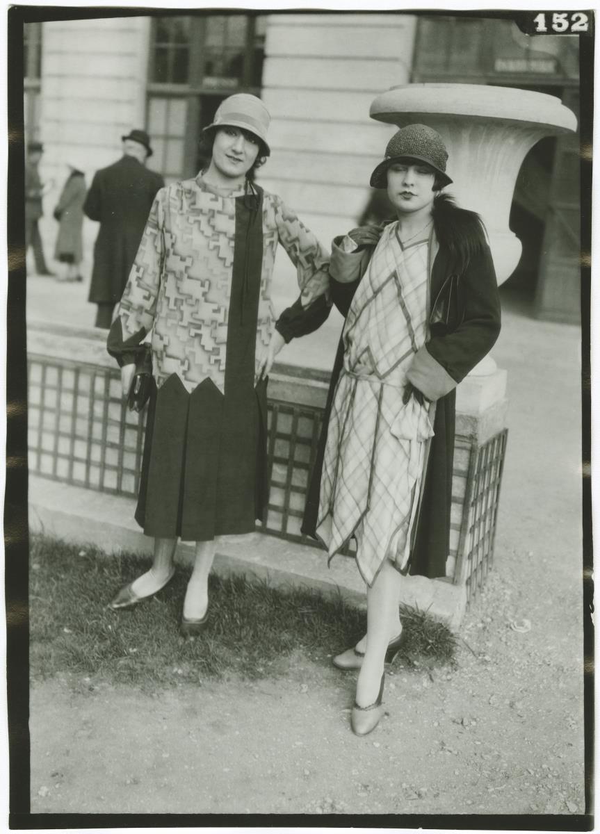 Frau in Kleid und Frau in Kleid und Mantel auf dem Rennplatz in Auteuil