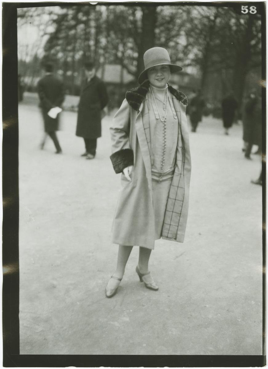 Frau in Kleid und Mantel auf dem Rennplatz in Auteuil