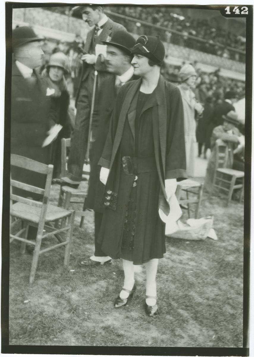 Frau in Ensemble und Herr in Anzug auf dem Rennplatz in Auteuil