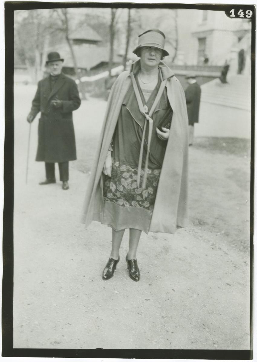 Frau in Kleid und Mantel auf dem Rennplatz in Auteuil