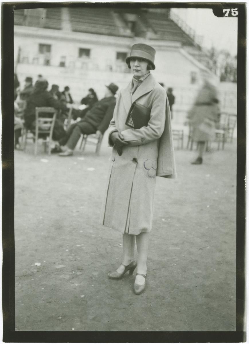 Frau in Mantel auf dem Rennplatz in Auteuil
