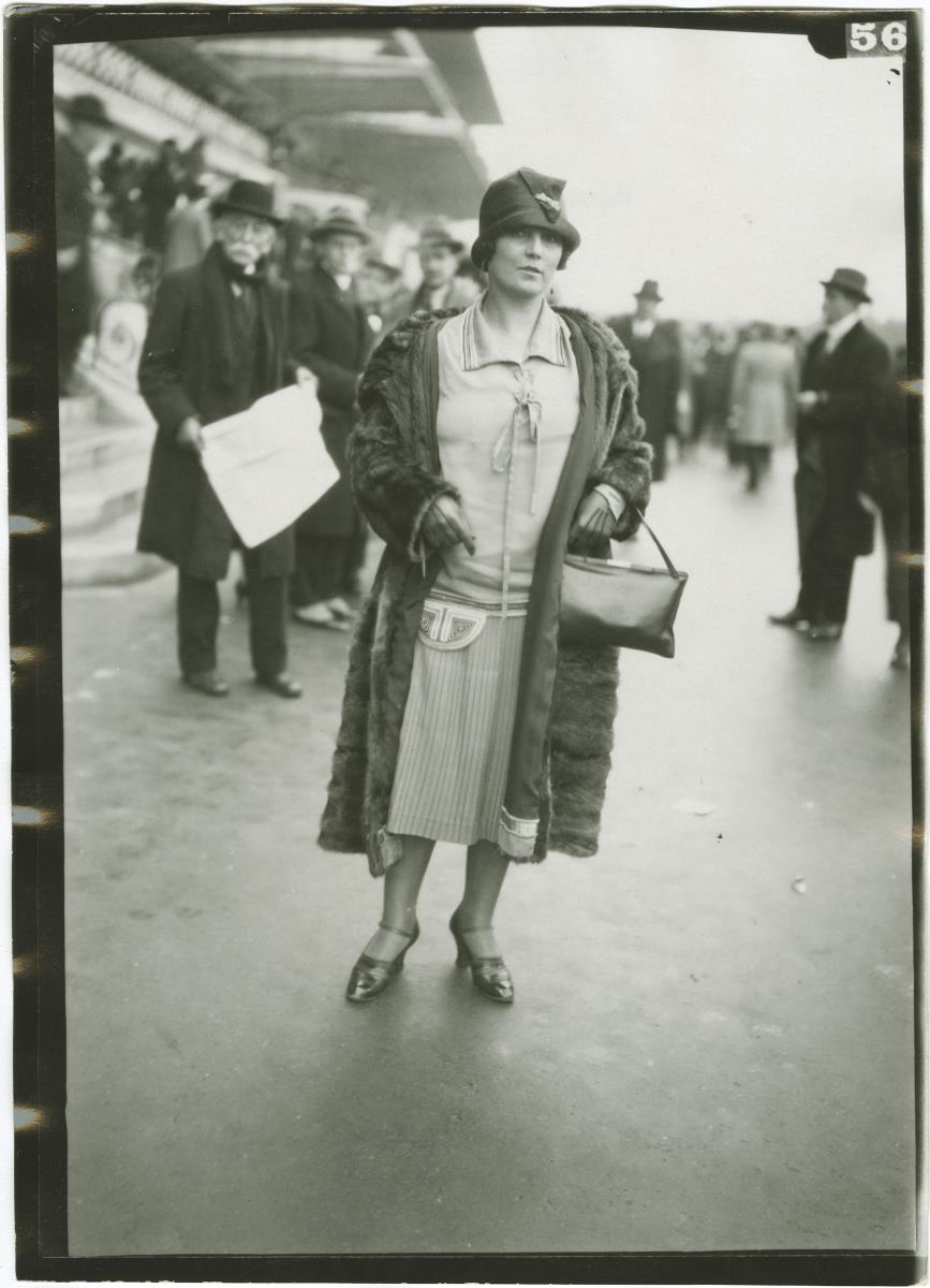 Frau in Kleid und Mantel auf dem Rennplatz in Auteuil
