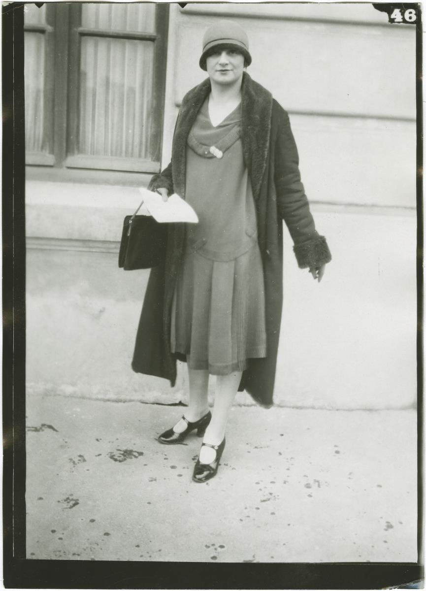 Frau in Kleid und Mantel auf dem Rennplatz in Auteuil