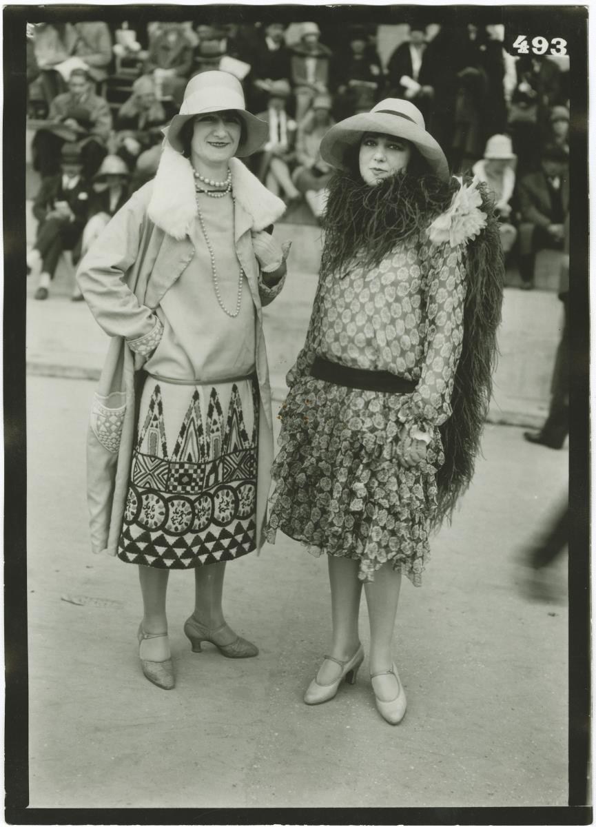 Frau in Kleid und Mantel und Frau in Kleid auf dem Rennplatz in Auteuil
