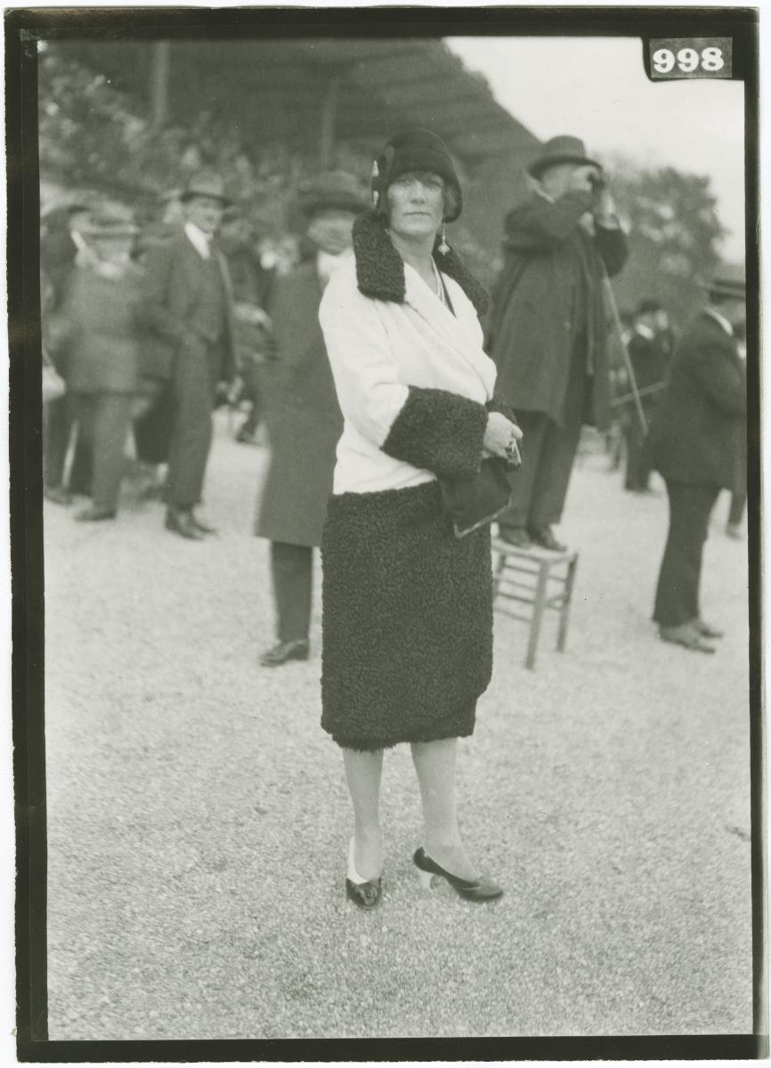Frau in Mantel auf dem Rennplatz in Longchamp