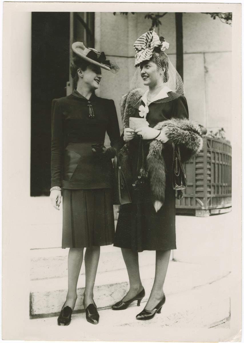 Frauen mit Hüten und in Kostümen auf dem Rennplatz in Longchamp