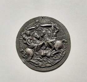 Runde Plakette mit Reiterkampf