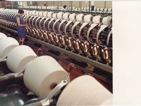 Lauffenmühle, Arbeiterin kontrolliert eine Spinnmaschine