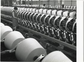 Lauffenmühle, Arbeiterin kontrolliert eine Spinnmaschine