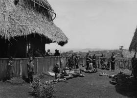 Männer und Frauen mit ethnographischen Gegenständen auf der Mission.