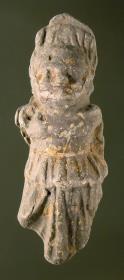Karikierte langbekleidete (weibliche?) Figur, hinten abgeflacht