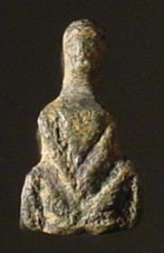 Kleine Statuette einer mit gespreizten Beinen hockenden nackten Frau, im Nacken eine Öse