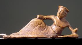 Archaische Statuette eines gelagerten Mannes, von einem Gerät