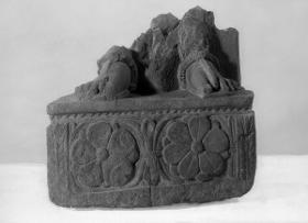 Füße eines stehenden Bodhisattva (Fragment). Sockelrelief: zwei Lotosrosetten