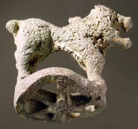 Stark korrodierte geometrische Statuette eines Löwen auf verbogener radförmiger Basis