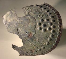 Fragment eines Oberschenkelschutzes von Blech mit Buckeln und Ornament