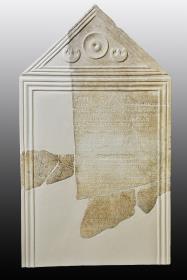 Ursprünglich an einer Wand besfestigte giebelbekrönte Stele mit Hymnos an Zeus für die Rettung vor der Pest
