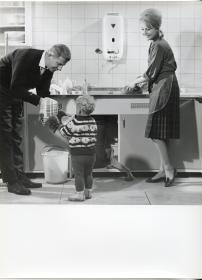 Junkers, Hausfrau, Vater und Kind an Küchenspüle mit Gas-Durchlauferhitzer (Werbung für Junkers Quell)