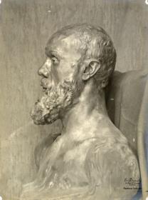 Die Büste Jean-Paul Laurens vor der fleckigen Mauer im Atelier du Dépôt des marbres, hinter der Büste eine Stoffdraperie