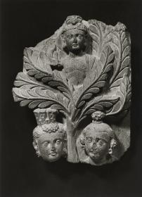 Erzählende Szene, evtl. Fragment aus einer Szene des Dahinscheidenden Buddha (mahaparinirvana): Yaksha in Shala-Baum, Kopf einer Stadtgöttin und eines Klagenden