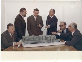 Leitz, Geschäftsführung diskutiert das Modell des Fabrik-Neubaus (Entwurf von Georg Heinrichs und Hans C. Müller)