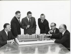 Leitz, Geschäftsführung diskutiert das Modell des Fabrik-Neubaus in Stuttgart-Feuerbach (Entwurf von Georg Heinrichs und Hans C. Müller)